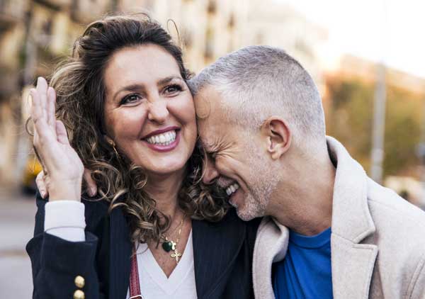 Lovely mature couple in love bonding together in the street. Affectionate mid adult woman and man showing affection and laughing. Mature couple after assisting Couples Therapy in Tucson