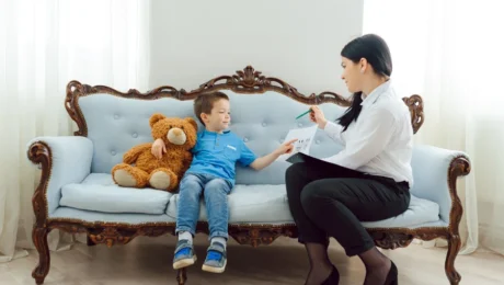 psychological-testing-kids-teens-signs-evaluation-involves A calm, professional clinic setting with a parent and child speaking with a clinician about psychological testing, with subtle educational materials nearby.